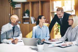 Diverse businesspeople laughing together during an office meeting